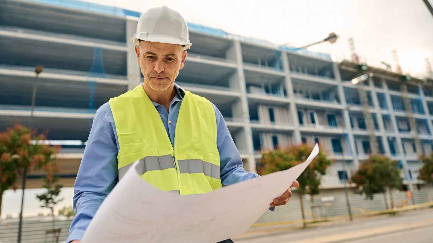 Professional contractor reviewing construction project plans for performance bond application