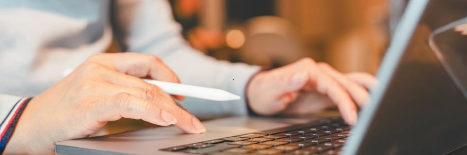 Hands working on laptop to complete mortgage broker bond application online