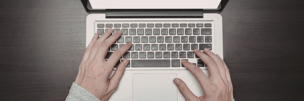 Hands typing on laptop — applying for a VA fiduciary bond online