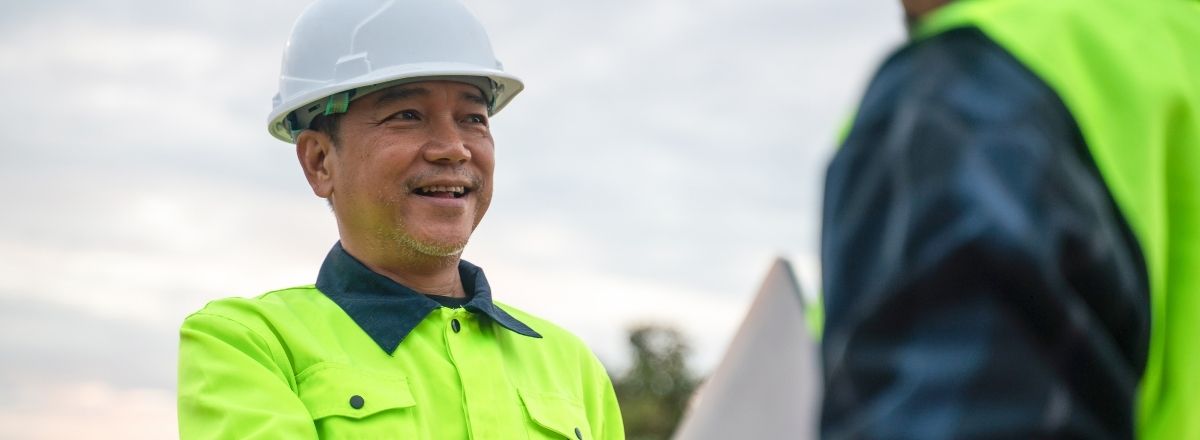 Licensed contractor smiling and shaking hands on job site after getting bonded