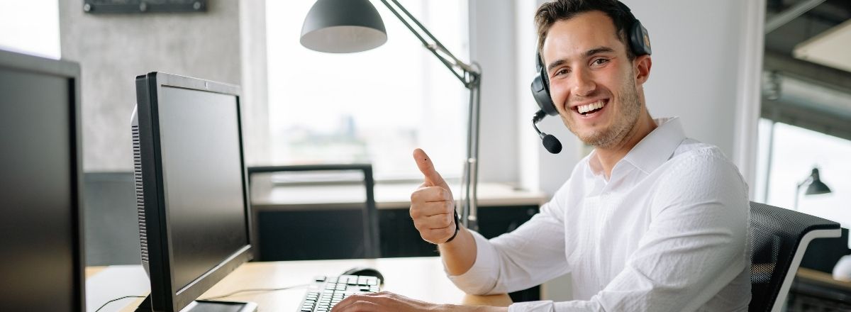 Man wearing a headset smiling and giving a thumbs up after getting approved for a utility bond