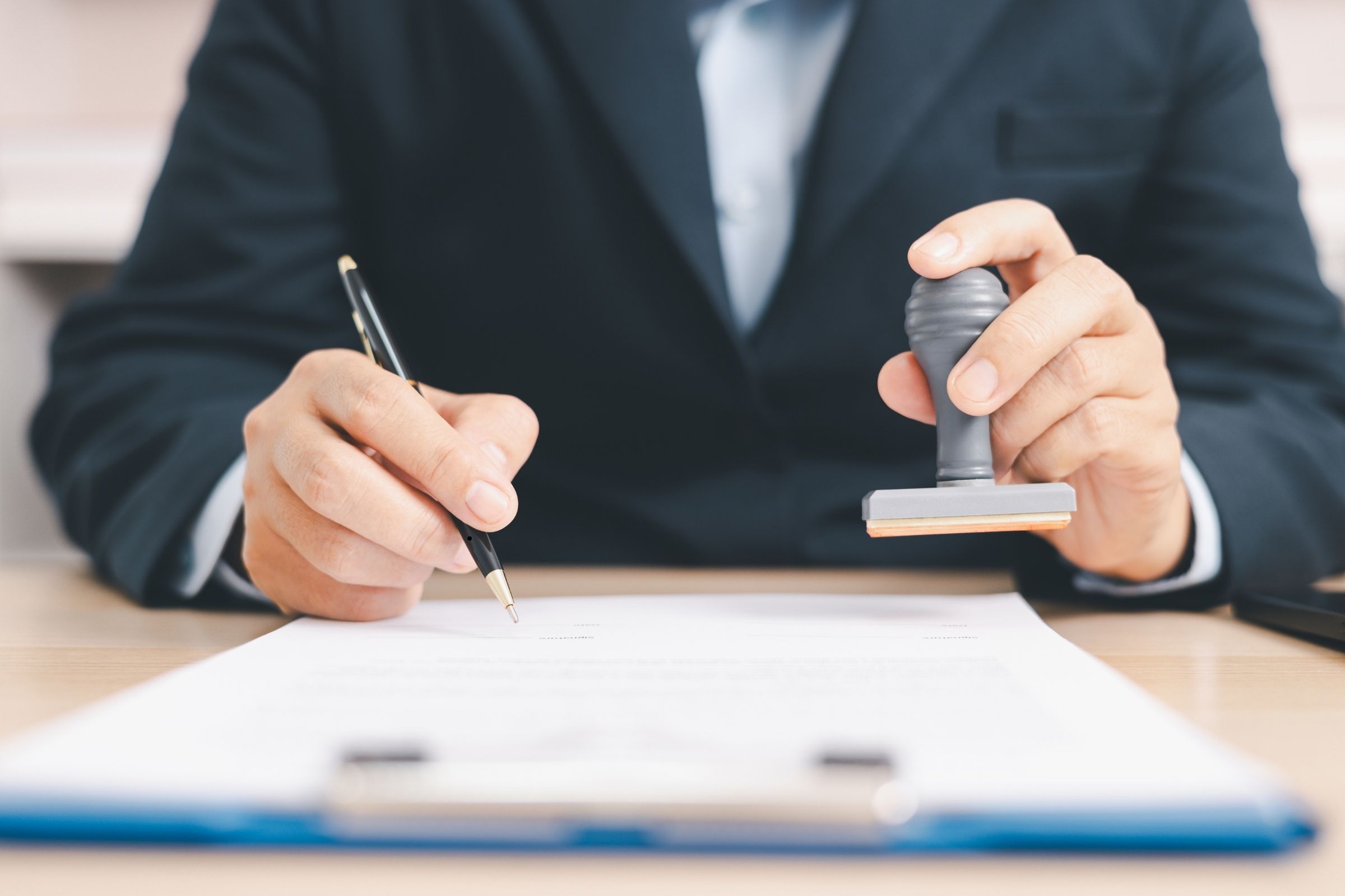 Contractor signing bond application documents with approval stamp